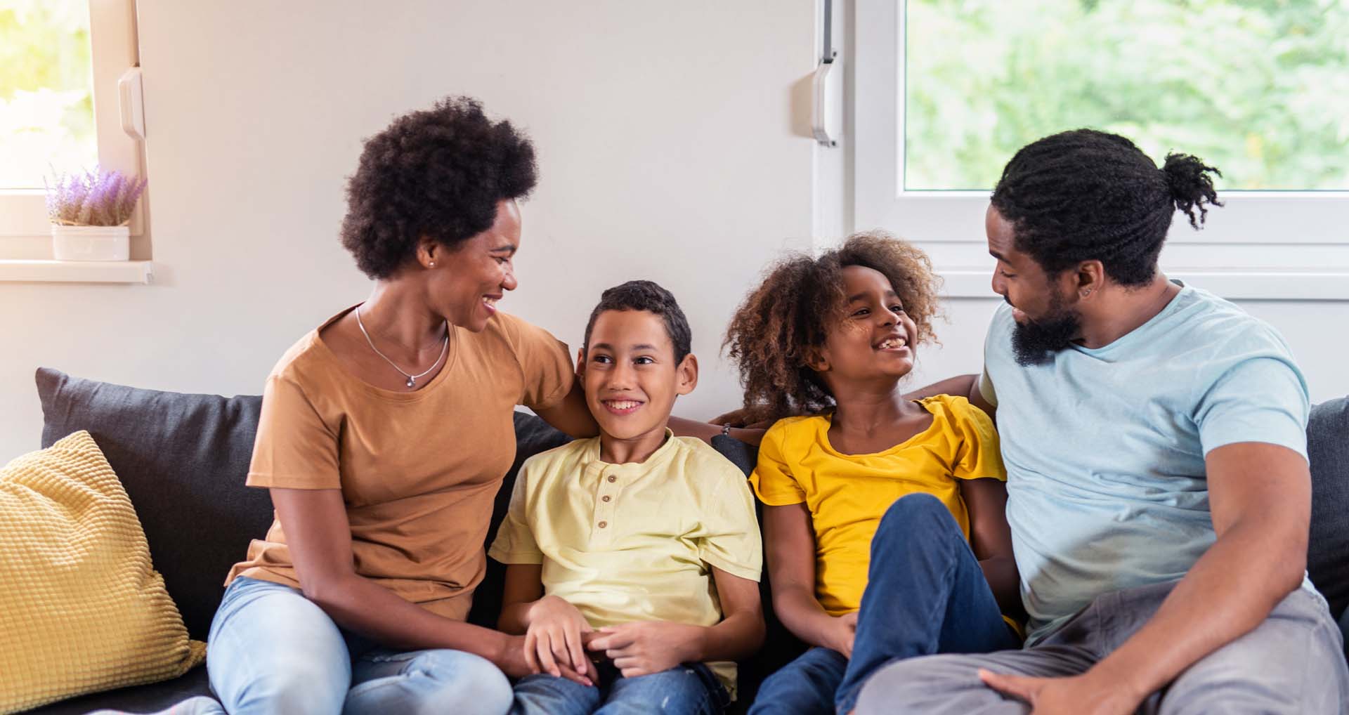 Man and woman sitting with boy and girl on couch